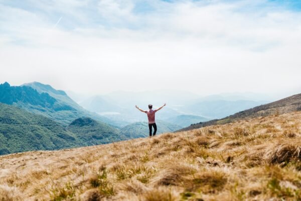 Man on a hilltop looking over mountains, symbolizing financial freedom
