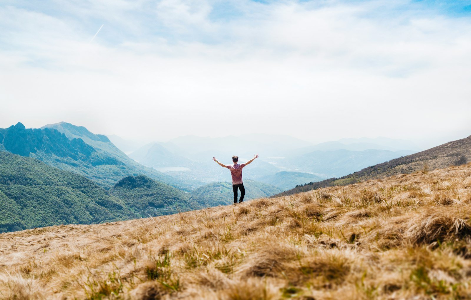 Man on a hilltop looking over mountains, symbolizing financial freedom
