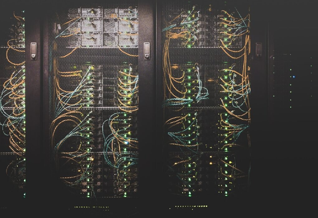 Server racks and network cables in a data center, representing tech's carbon footprint