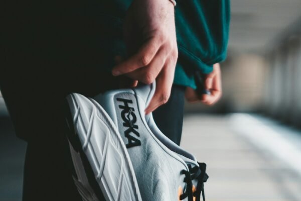 Person holding running shoes, symbolizing a small daily habit