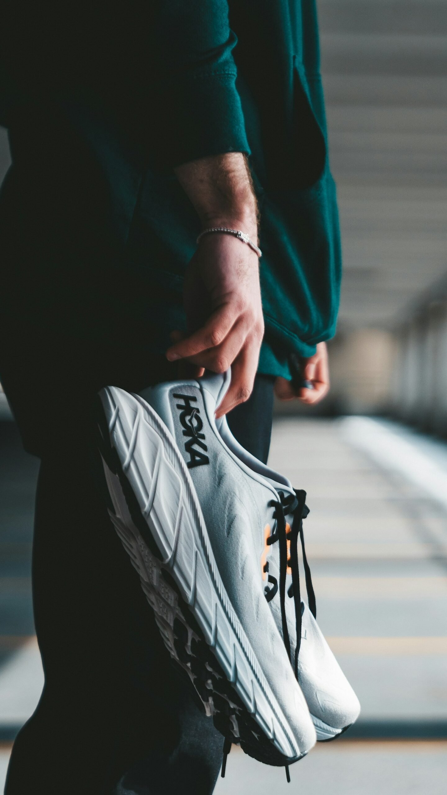 Person holding running shoes, symbolizing a small daily habit